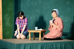 控えめな性格の主人公（左）と祖母を演じる劇団員＝佐賀市の金立小
