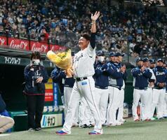 　プロ野球西武のファン感謝イベントで行われた引退セレモニーで、花束を手にファンの拍手に応える松坂大輔さん＝４日、埼玉県所沢市のメットライフドーム