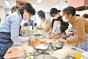 和やかな雰囲気で日本料理をつくる参加者たち＝佐賀市のアバンセ
