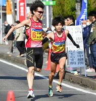 ９区区間賞の藤田啓生（左）から１０区区間新の坂本佳太へのたすきリレー。９連覇を果たした小城市は、八つの区間賞を獲得して他を圧倒した