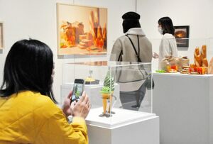 ミニチュアライフ展の会場。スマートフォンを手に撮影する人も多い＝佐賀市の県立美術館