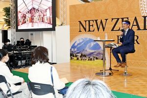 ハカの映像を流しながらニュージーランド文化について話す杉村佳彦さん。来場者は互いに距離を取り、トークショーを楽しんだ＝佐賀市のモラージュ佐賀