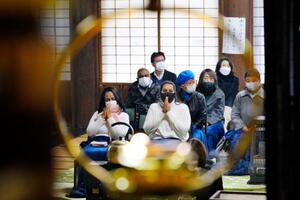 　ウィシュマさんの誕生日に合わせて愛知県愛西市の明通寺を訪れ、手を合わせるポールニマさん（手前左から２人目）ら＝５日午後