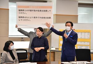 対策本部会議で、ボードを使って呼び掛ける山口祥義知事（右）＝１３日午前、佐賀県庁
