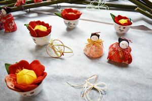 かわいらしいひな人形と、椿の花飾り＝佐賀市の佐賀婦人会館