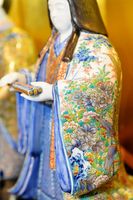 細密画で知られる武雄市の陶芸家、葉山有樹さんが手掛けたひな人形。衣装には花や文様が微細に描かれ、感嘆の声を漏らす来場者も＝有田町幸平の鷹巣瑞光堂