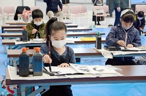 席書会で慎重に筆を運ぶ子どもたち＝有田町の焱の博記念堂