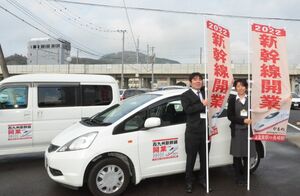 新幹線開業をＰＲするのぼり旗と車に付けるマグネット式シールの活用を呼び掛ける武雄商工会議所の職員
