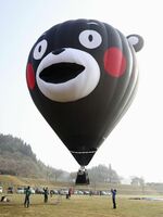 　デビュー飛行をする「くまモン」の顔をかたどった熱気球＝１４日午前、熊本県阿蘇市