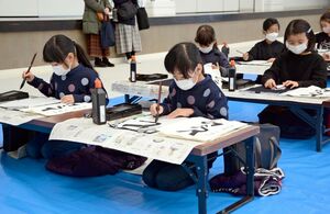 席書会で慎重に筆を運ぶ子どもたち＝有田町の焱の博記念堂