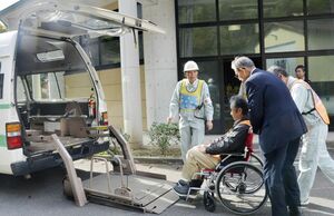 　中国電力島根原発での事故を想定した総合防災訓練で、車いすのまま福祉タクシーに乗せられる要支援者役の参加者＝２０１９年１１月、松江市