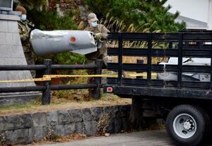 　米軍機が投棄した燃料タンクの一部を落下現場から回収する米軍関係者＝１日午後、青森県深浦町