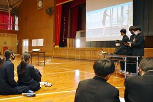 トレーニング方法を紹介する３年生と画面を見ながら聞く生徒たち＝佐賀市の佐賀東高体育館