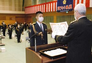 平野欽也校長（右）から卒業証書を受ける馬場寛大さん（県警提供）