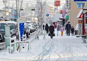 雪が降り積もった佐賀市街地。路面は滑りやすく、車がゆっくりと進んでいた＝１８日午前７時３７分、佐賀市天祐