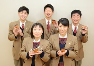 記念品を手に喜ぶ神埼清明高の卒業生たち＝神埼市の同校