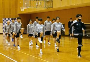 阿久津洋介さん（右）から走る時の足の使い方を学ぶ佐賀バルーナーズＵ―１５の選手たち＝小城市の芦刈文化体育館