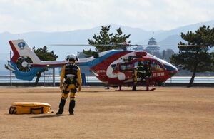 防災ヘリに乗り込む市消防本部の隊員ら＝唐津市二タ子の市浄水センター運動広場