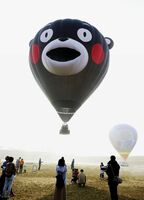 　デビュー飛行をする「くまモン」の顔をかたどった熱気球＝１４日午前、熊本県阿蘇市