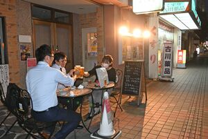 飲食店の屋外に設けられたテラス席で飲食を楽しむ人たち＝佐賀市の中央大通り
