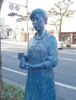 三角フラスコを手にした黒田チカの銅像＝佐賀市の中央大通り