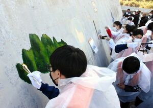 防波堤に絵を描く生徒たち＝唐津市の屋形石漁港