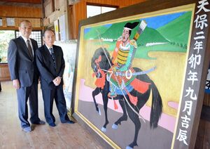 修復された大絵馬。武者の勇壮な姿を描いている。修復に当たった中村啓三さん（左）と杉光定さん＝鹿島市の五の宮神社
