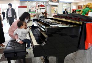 設置されたグランドピアノに触れる家族連れ＝唐津市のＪＲ唐津駅