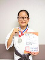 少林拳の国際大会準優勝の賞状とメダルを手に益田菜愛さん