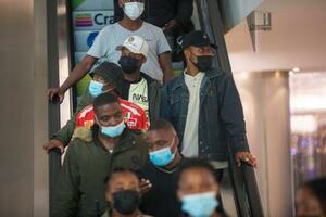 　２６日、南アフリカ・ヨハネスブルクの商業施設で、マスク姿でエスカレーターに乗る人たち（ＡＰ＝共同）