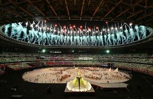 　東京五輪の開会式で打ち上げられる花火。手前は点火された聖火台＝７月２３日夜、国立競技場