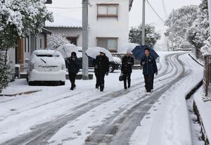 大雪の中、滑らないように気をつけながら登校する中学生＝８日午前８時５５分ごろ、鳥栖市田代本町