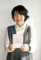 「さがリトルベビーハンドブック」を持つ江口玉恵さん。小児科で発達具合を見る時や、大人になってからの受診でも役に立つという